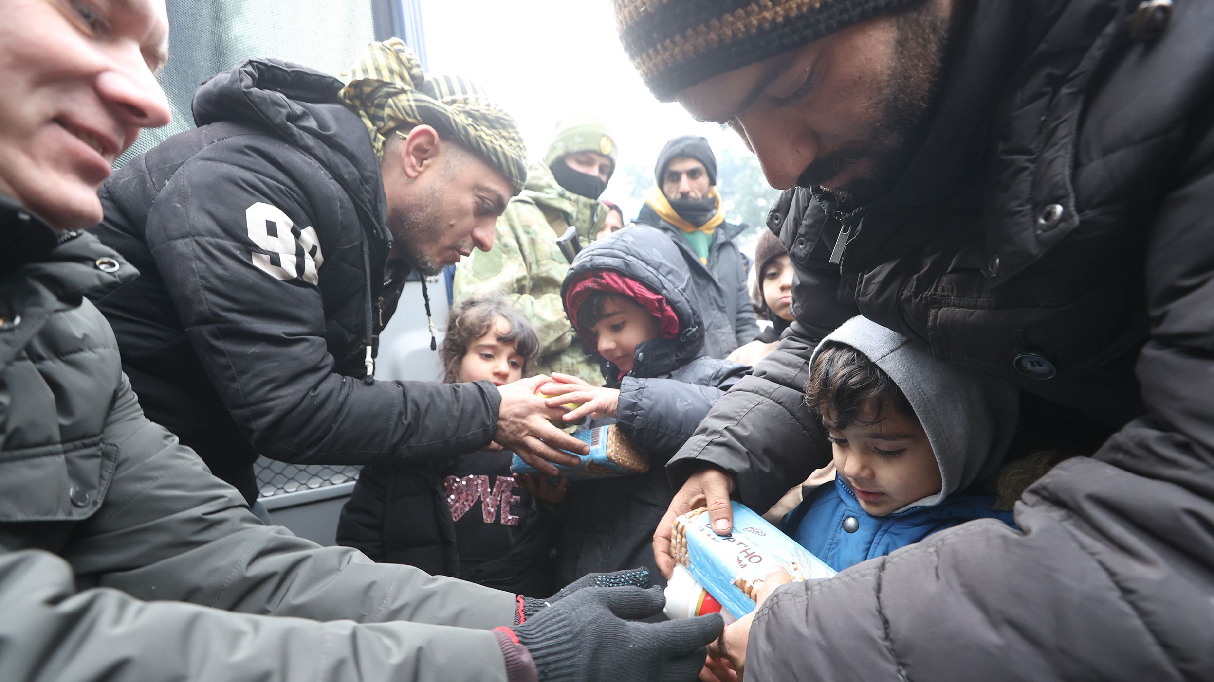 Migrants receive food and water on Wednesday, November 10.
