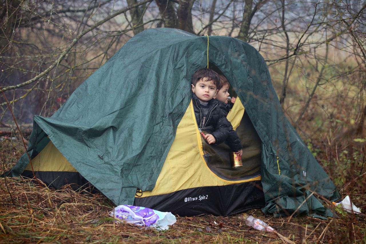 Young migrants peer out of a tent on Monday, November 8.