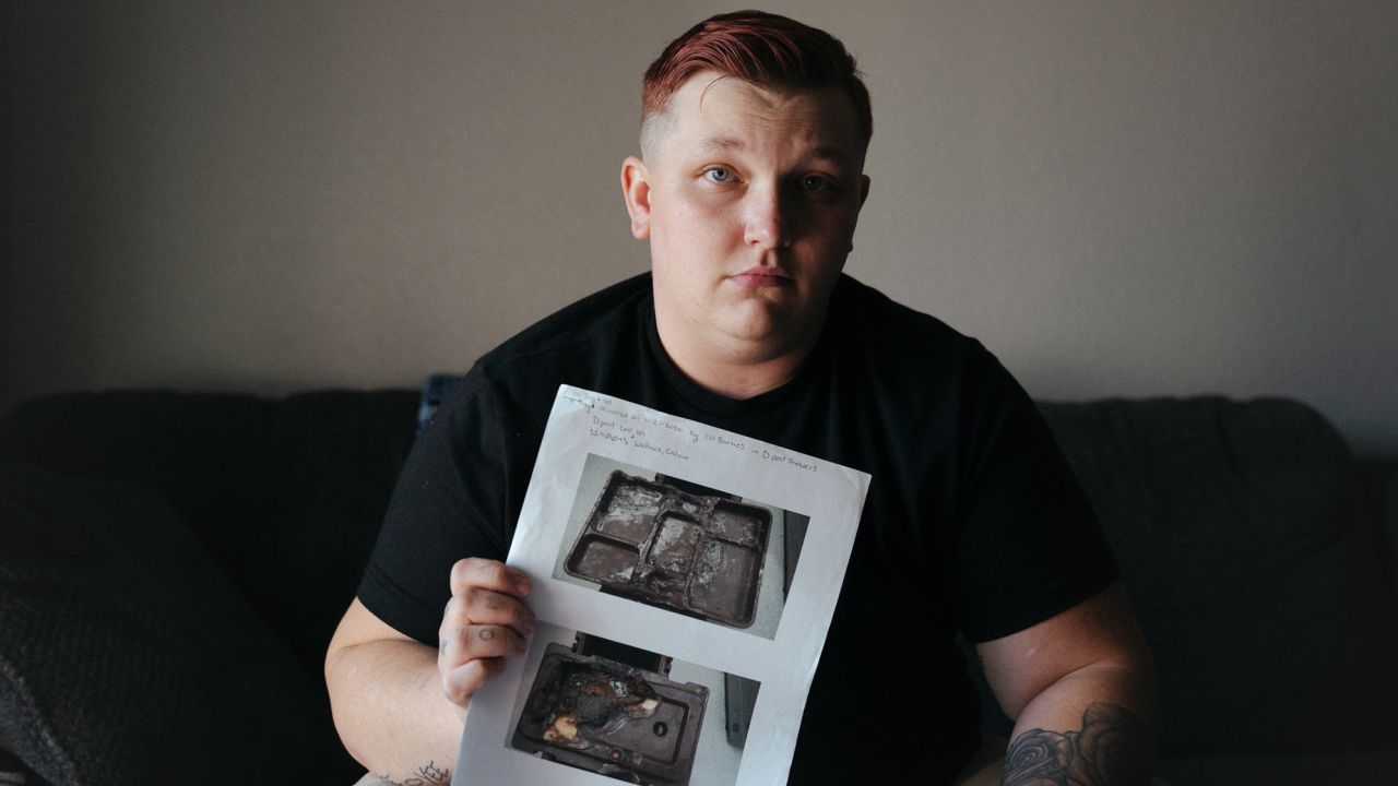 Former correctional officer Justin Chmidling holds documentation of reports he filed while working at the Leavenworth Detention Center, including photos of cafeteria trays that he said inmates were using as weapons.
