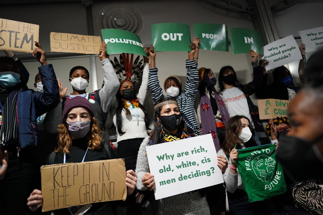 Climate activists protest as they build a human corridor at the start of the Closing Plenaries session, protesting "Polluters OUT, People IN" on November 11, 2021.