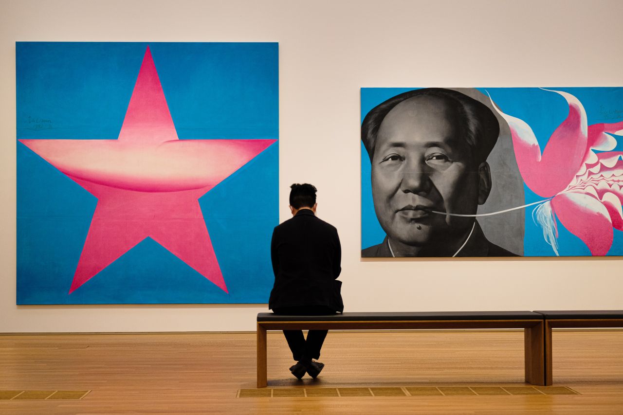 A visitor sits in front of "Rouge 1992" by artist Li Shan.