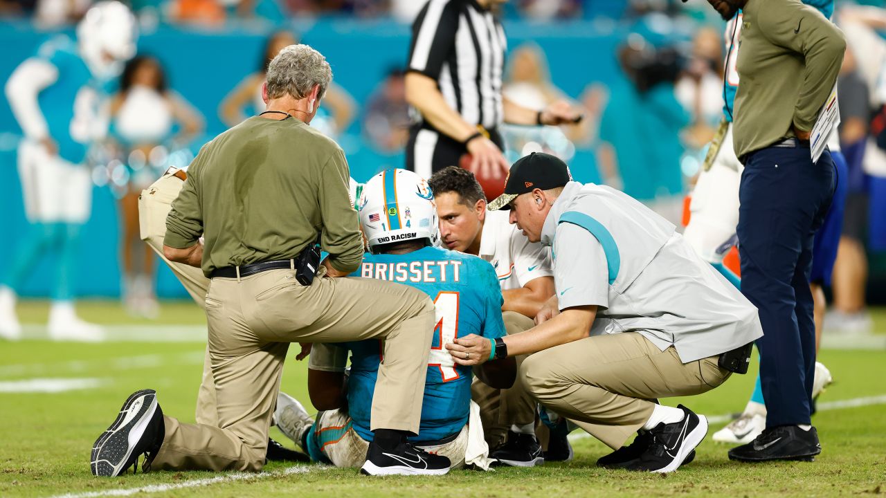 Jacoby Brissett is looked over by medical staff on the field after a play against the Ravens.