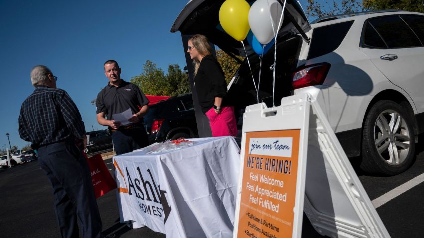 Recruiters speak with a potential applicants during a tail gate job fair in Leesburg, Virginia on October 21, 2021.