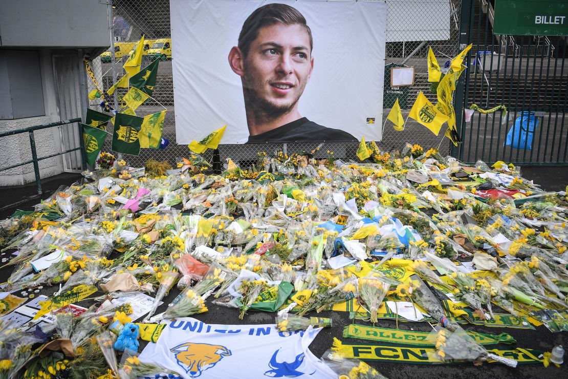 Yellow flowers are displayed in front of the portrait of Argentinian forward Emiliano Sala in Nantes on February 8, 2019.