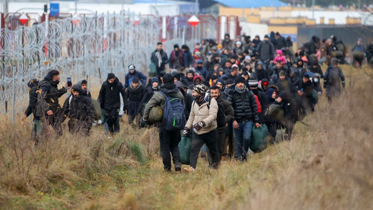 A group of migrants walk along the Belarusian-Polish border in Belarus' Grodno region on November 12, 2021. 
