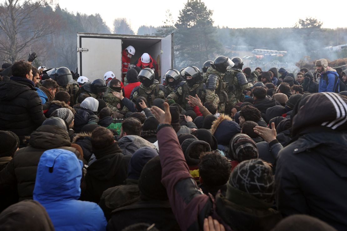 Migrants gather to receive humanitarian aid in a camp on the Belarusian-Polish border in Belarus' Grodno region on November 12, 2021. 