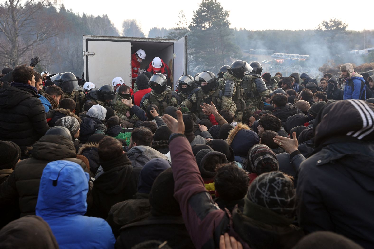 Migrants gather to receive humanitarian aid at a border camp on Friday, November 12. 