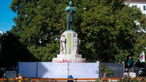 Lena Floerl (R), 25, takes part in a "vigil of shame" on October 6, 2020, to prevent city authorities removing graffiti from the statue of Karl Lueger, a former mayor of Vienna famous for his anti-Semitic views.