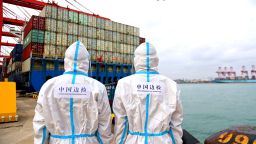 QINGDAO, CHINA - NOVEMBER 7, 2021 - Two policemen patrol beside cargo ships at the Huangdao Entry-exit border inspection station at Qingdao Port's foreign trade container terminal in East China's Shandong province, Nov. 7, 2021. The value of China's imports and exports rose 22.2 percent year-on-year in the first 10 months of this year. (Photo credit should read Yu Fangping / Costfoto/Barcroft Media via Getty Images)