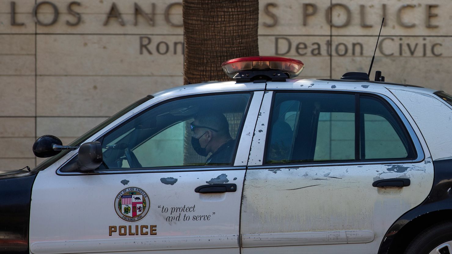 A member of the LAPD sits inside his squad car, parked outside their headquarters on 1st St. in downtown Los Angeles.