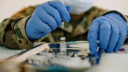 A member of the National Guard prepares a dose of the Pfizer-BioNTech Covid-19 vaccine at the University of New Orleans Lakefront Arena drive-through facility in New Orleans, Louisiana, US, on August 24, 2021. 