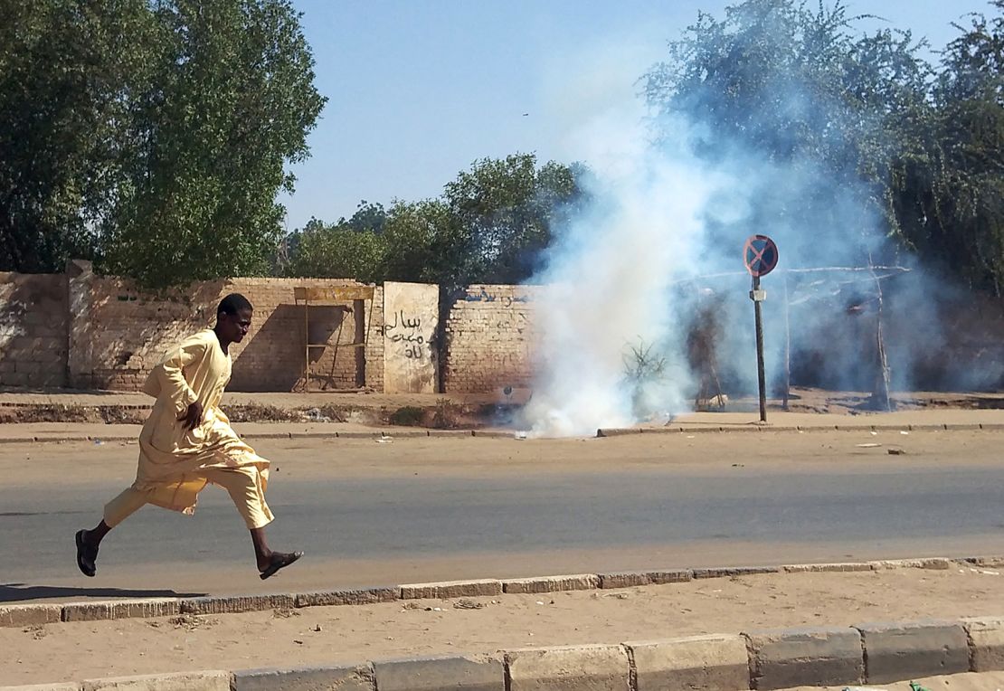 A Sudanese opponent of the military coup runs from tear gas launched by security forces during a protest in city of Umdurman, on November 13.