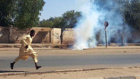 A Sudanese opponent of the military coup runs from tear gas launched by security forces during a protest in city of Umdurman, on November 13.