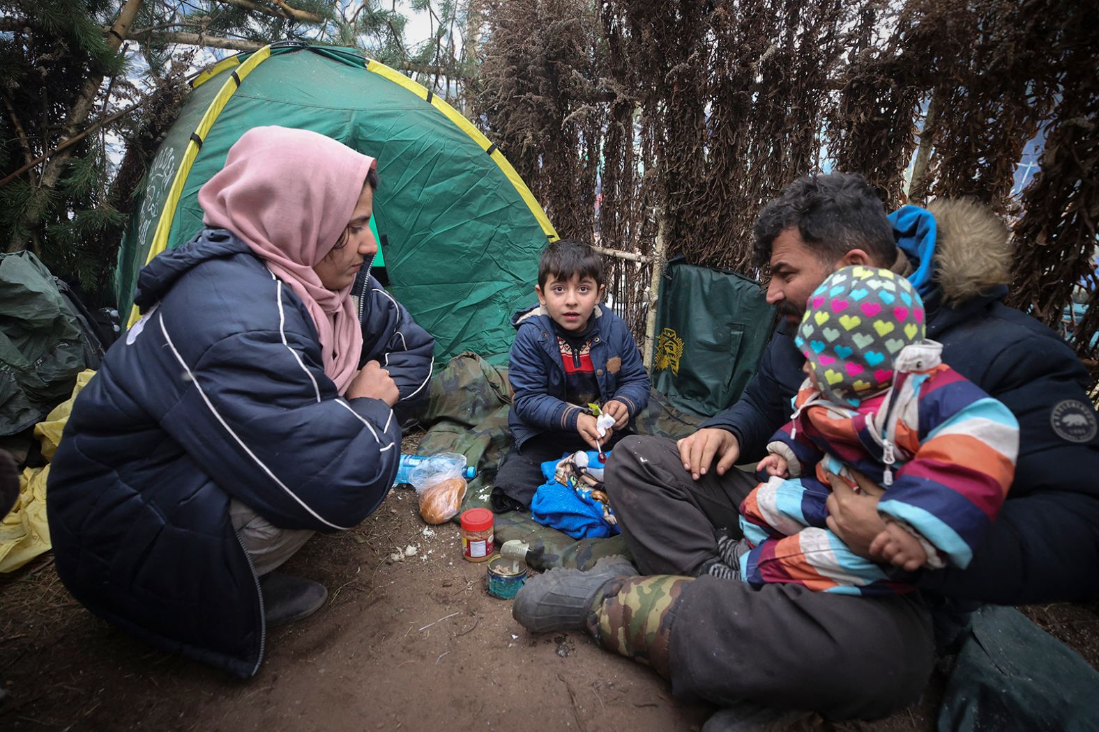 A family rests at a camp set up in the Grodno region on Saturday, November 13.