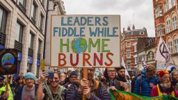 LONDON, UNITED KINGDOM - 2021/11/13: A demonstrator holds a placard which says 'Leaders Fiddle While Home Burns' during the protest.
Extinction Rebellion demonstrators marched through the city, disrupting the Lord Mayor's Show in protest against the "failure" of the COP26 climate change conference. The Lord Mayor's Show is a public parade marking the inauguration of the new Lord Mayor of the City of London, the capital's financial district. (Photo by Vuk Valcic/SOPA Images/LightRocket via Getty Images)