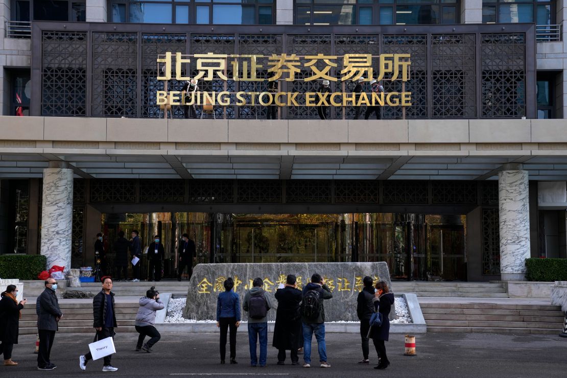 Journalists film workers installing the nameplate of Beijing Stock Exchange on Financial Street in Beijing, on Nov. 14. 