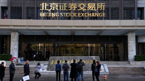 Journalists film workers installing the nameplate of Beijing Stock Exchange on Financial Street in Beijing, on Nov. 14. 