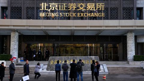 Journalists film workers installing the nameplate of Beijing Stock Exchange on Financial Street in Beijing, on Nov. 14.