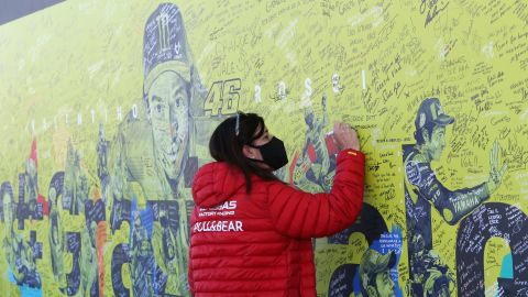 A fan writes a thank you message to Rossi on a mural dedicated to him before the Valencia GP.