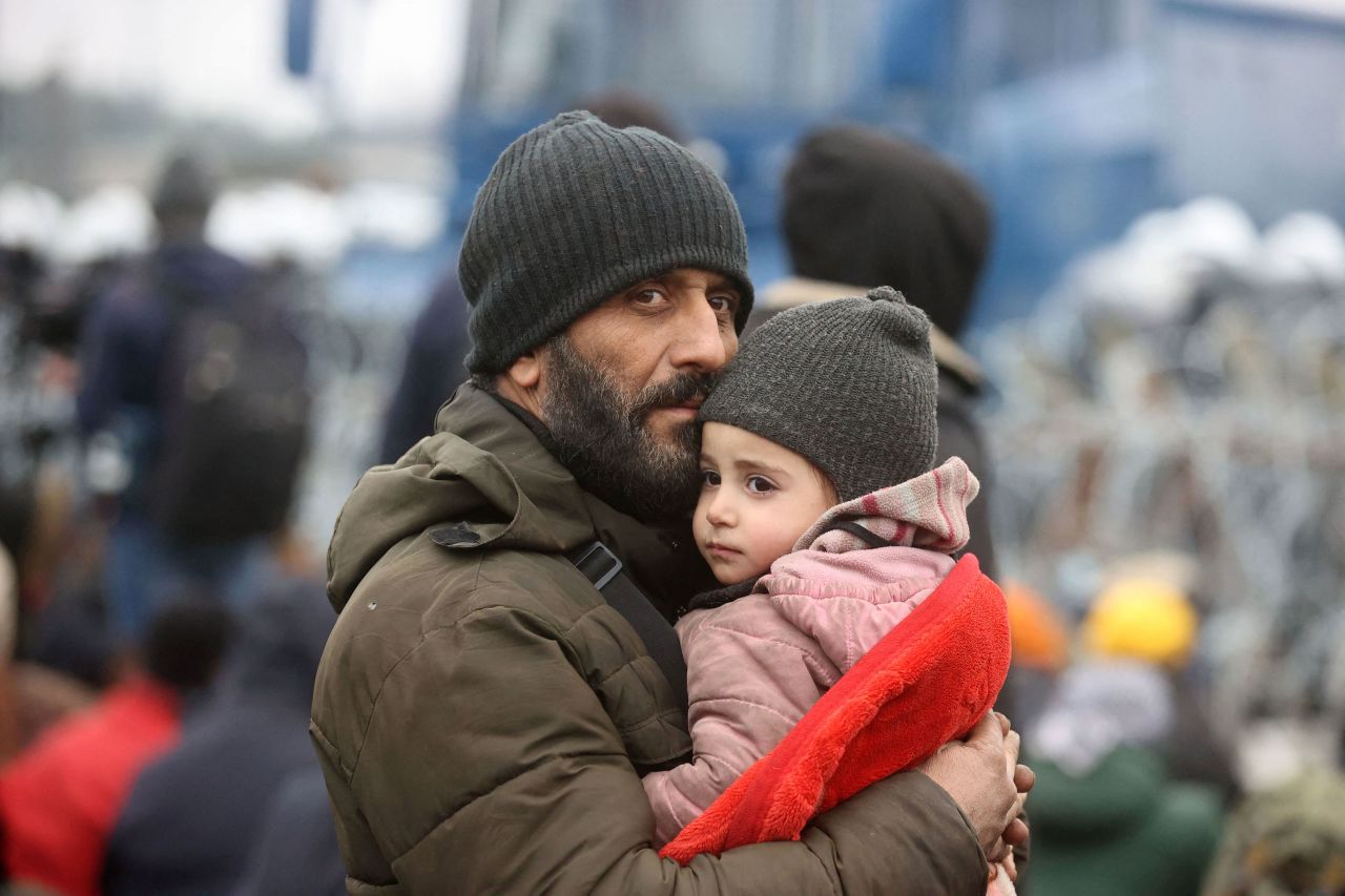 A man holds a child at the Bruzgi-Kuznica border crossing on Monday, November 15.
