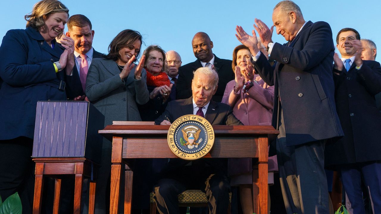 US President Joe Biden, flanked by Vice President Kamala Harris, takes part in a signing ceremony for H.R. 3684, the Infrastructure Investment and Jobs Act on the South Lawn of the White House in Washington, DC, on November 15, 2021