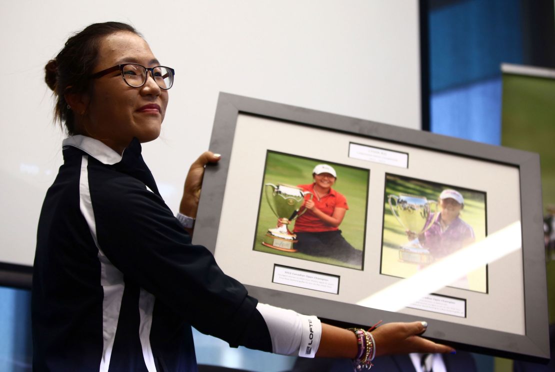 Ko is presented with a photo board displaying her wins following her arrival at Auckland International Airport on September 18, 2013 in New Zealand.