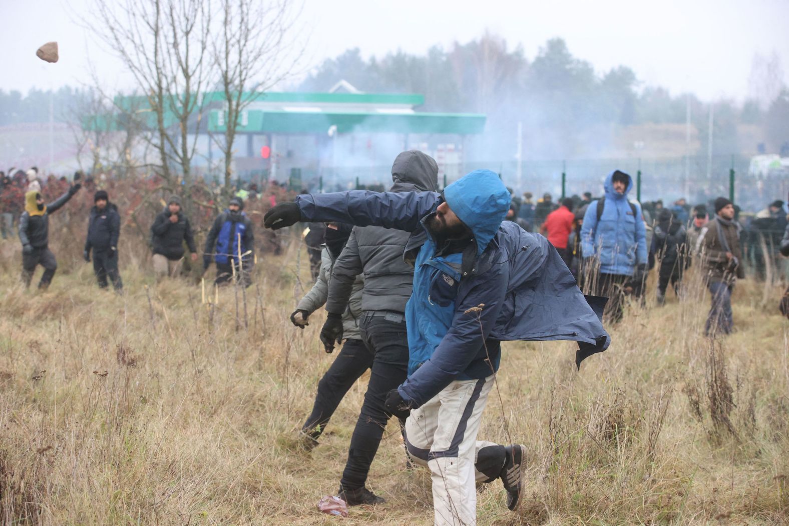Migrants throw stones at Polish border guards at the Bruzgi-Kuznica border crossing on Tuesday, November 16.