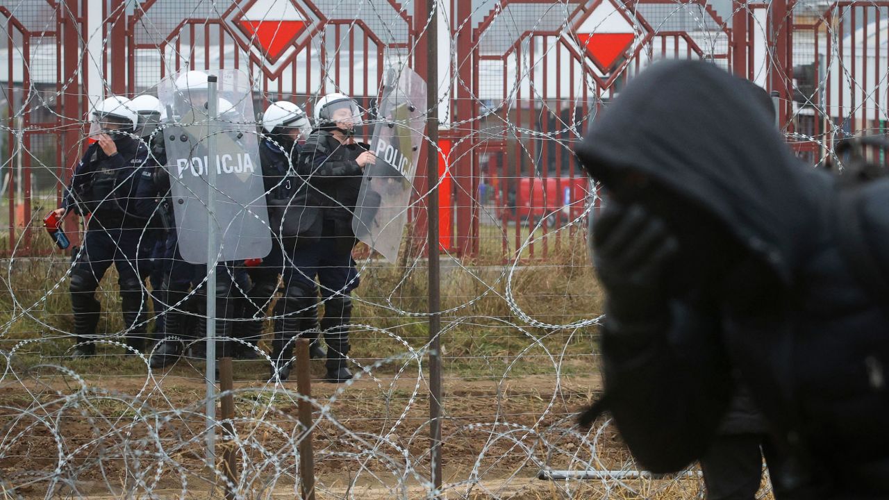 Polish border forces are seen through the barbed wire border fence during clashes Tuesday.