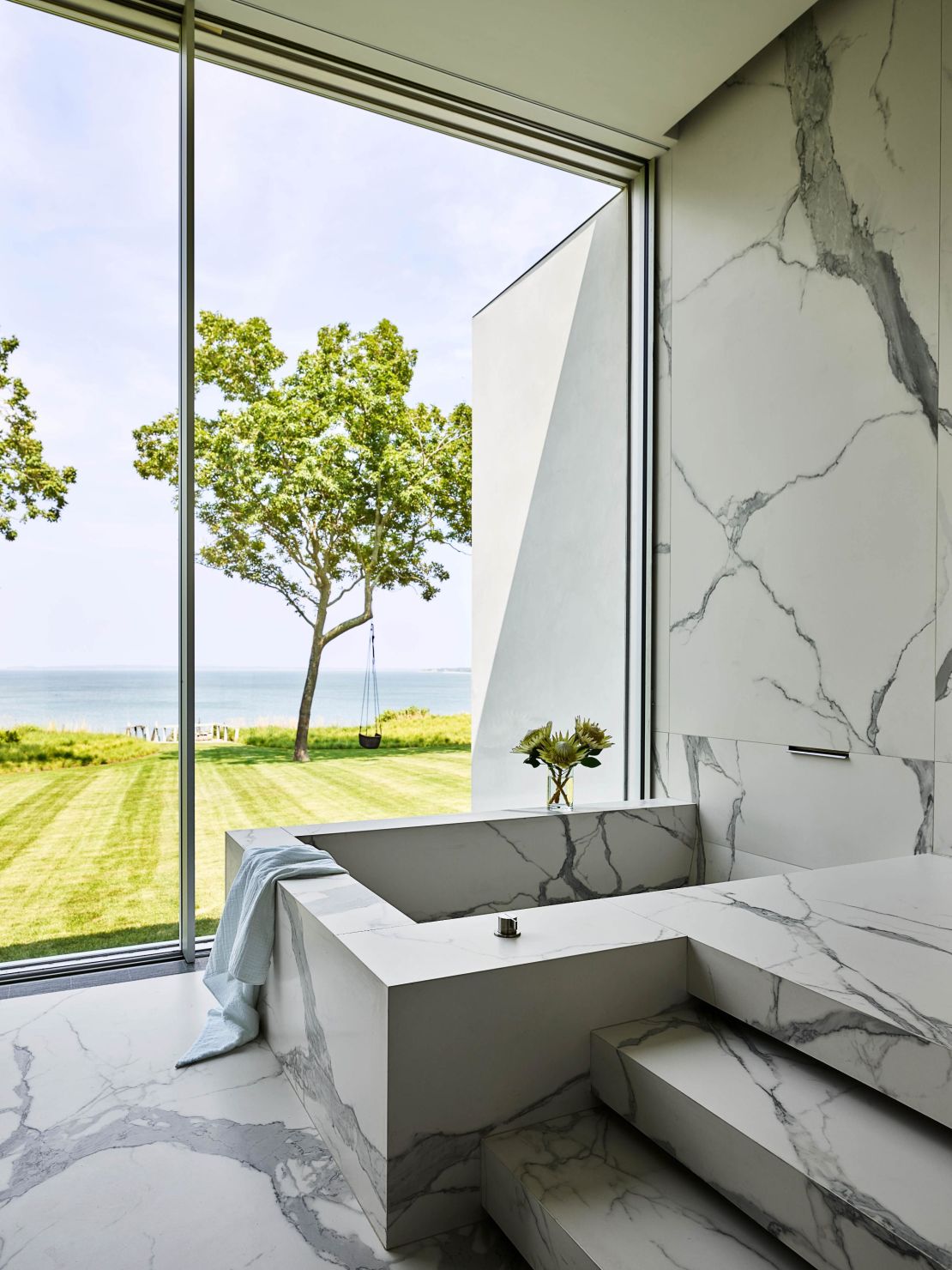 Jackman and Furness' marble-effect tiled bathroom stares out onto the horizon, creating a relaxing space to unwind in.