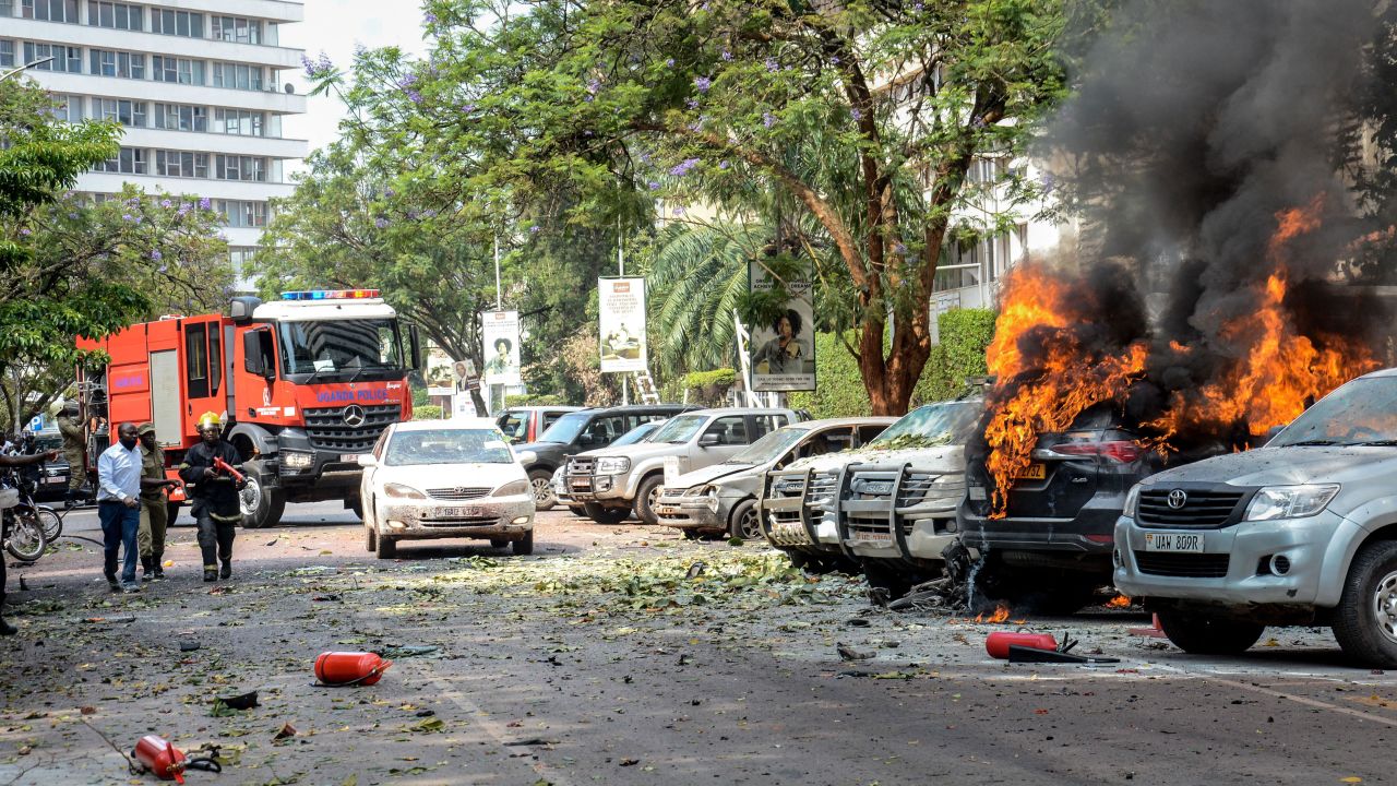 People extinguish fire caused by an explosion in central Kampala, Uganda, on November 16, 2021.