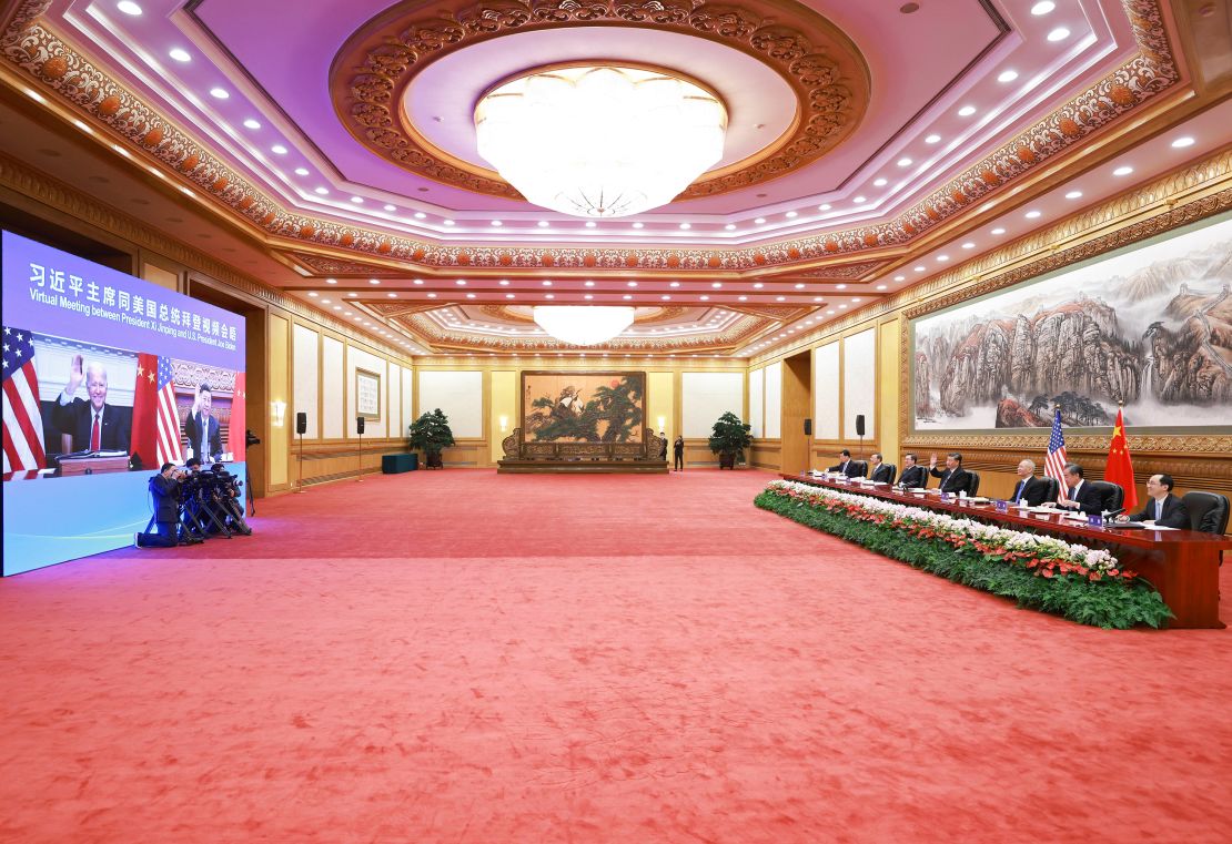 Chinese President Xi Jinping, fourth from right, waves as he greets US President Joe Biden via video link from Beijing on Tuesday in China.