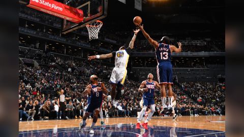 Golden State's Gary Payton II and Brooklyn's James Harden fight for a rebound.