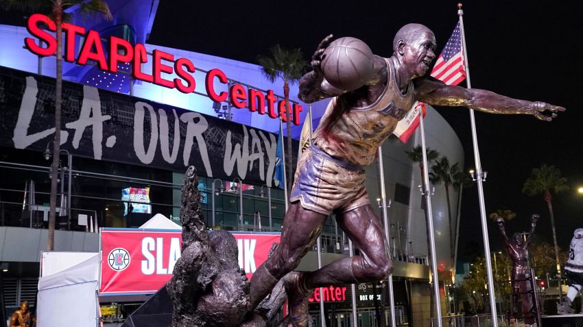 The statue of former Los Angeles Lakers Magic Johnson is seen in front of Staples Center following an NBA basketball game between the Los Angeles Clippers and the San Antonio Spurs Tuesday, Nov. 16, 2021, in Los Angeles. The Staples Center in downtown Los Angeles will be renamed Crypto.com Arena on Christmas. The home of the NBA's Lakers and Clippers, the NHL's Kings and the WNBA's Sparks will change its name after 22 years. (AP Photo/Mark J. Terrill)