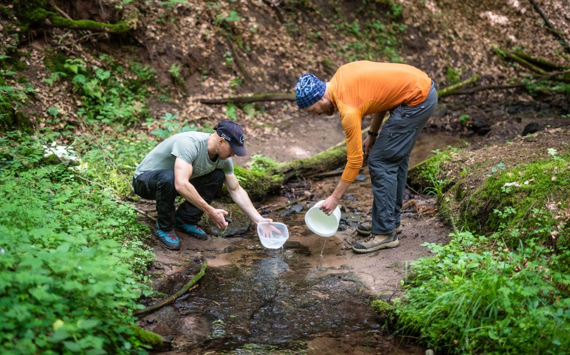 Two brothers clean their cooking equipment in a stream during a survival course in Baden-Wuerttemberg, Mainhardt, Germany, in June 2020. 