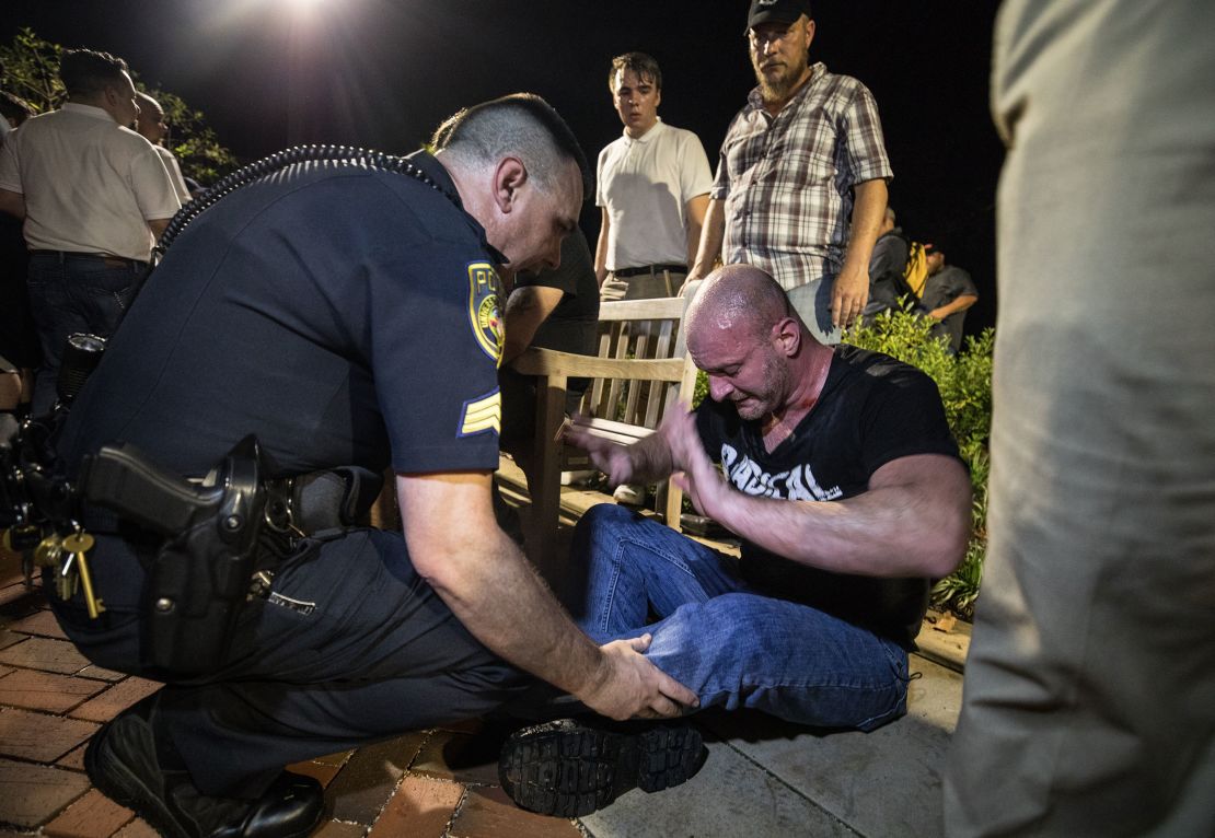 Christopher Cantwell is helped by police after he was overcome with tear gas as White nationalists carrying tiki torches marched through the University of Virginia campus the night before the Unite the Right rally in Charlottesville.