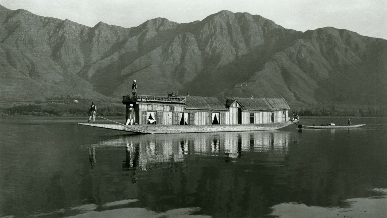 In this photo, estimated to have been taken between 1915 and 1919, a houseboat glides along Dal Lake.  