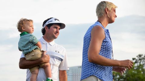 Watson waits with his wife Angie and their son Caleb on the 18th green after winning the 2014 Masters.