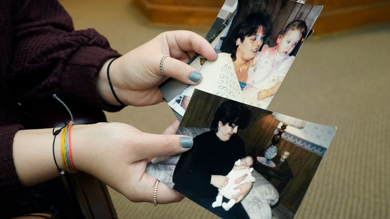 Kim Cox's daughter shows childhood photographs of herself and her late mother on November 13, 2021, in New Albany, Mississippi. 