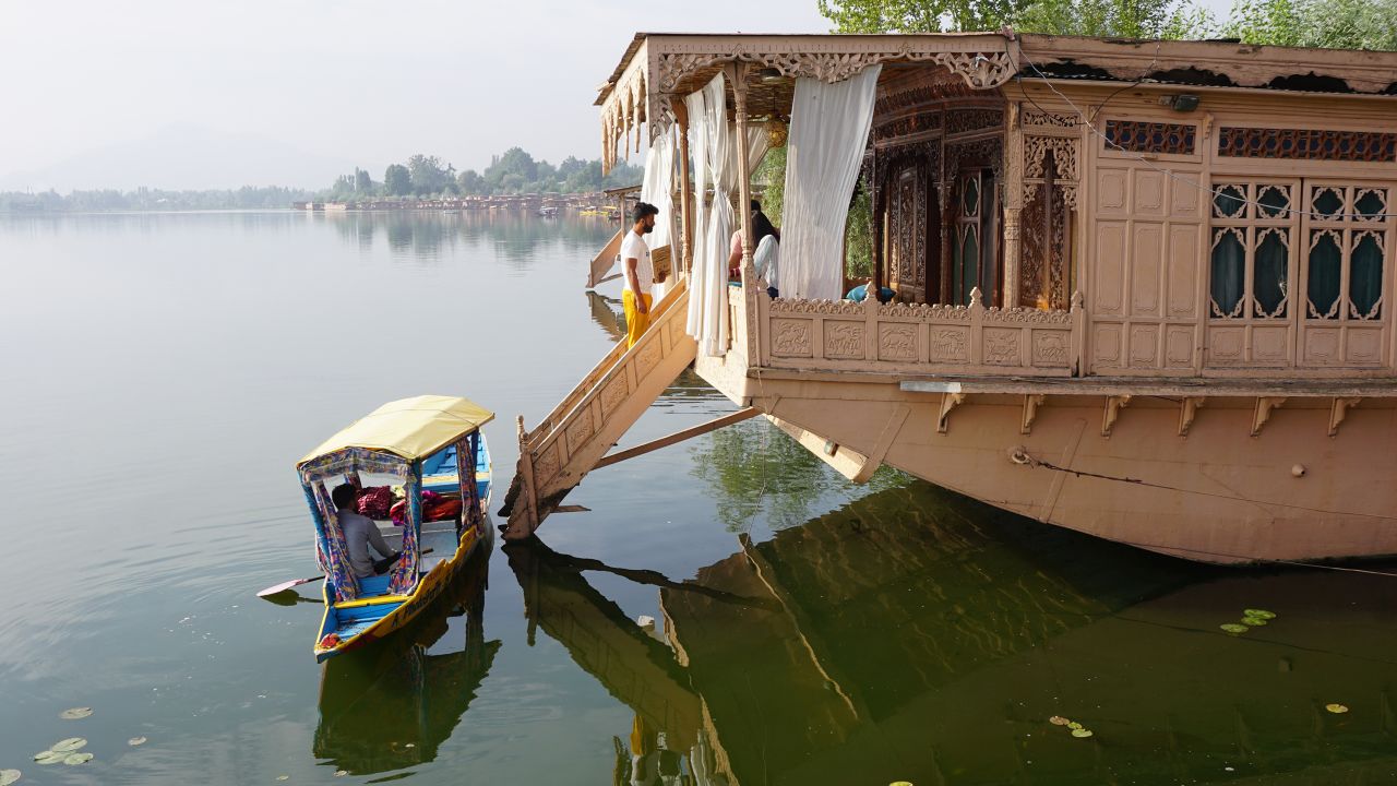 A shikara drops a passenger off at a houseboat moored on Srinagar's Nigeen Lake.    