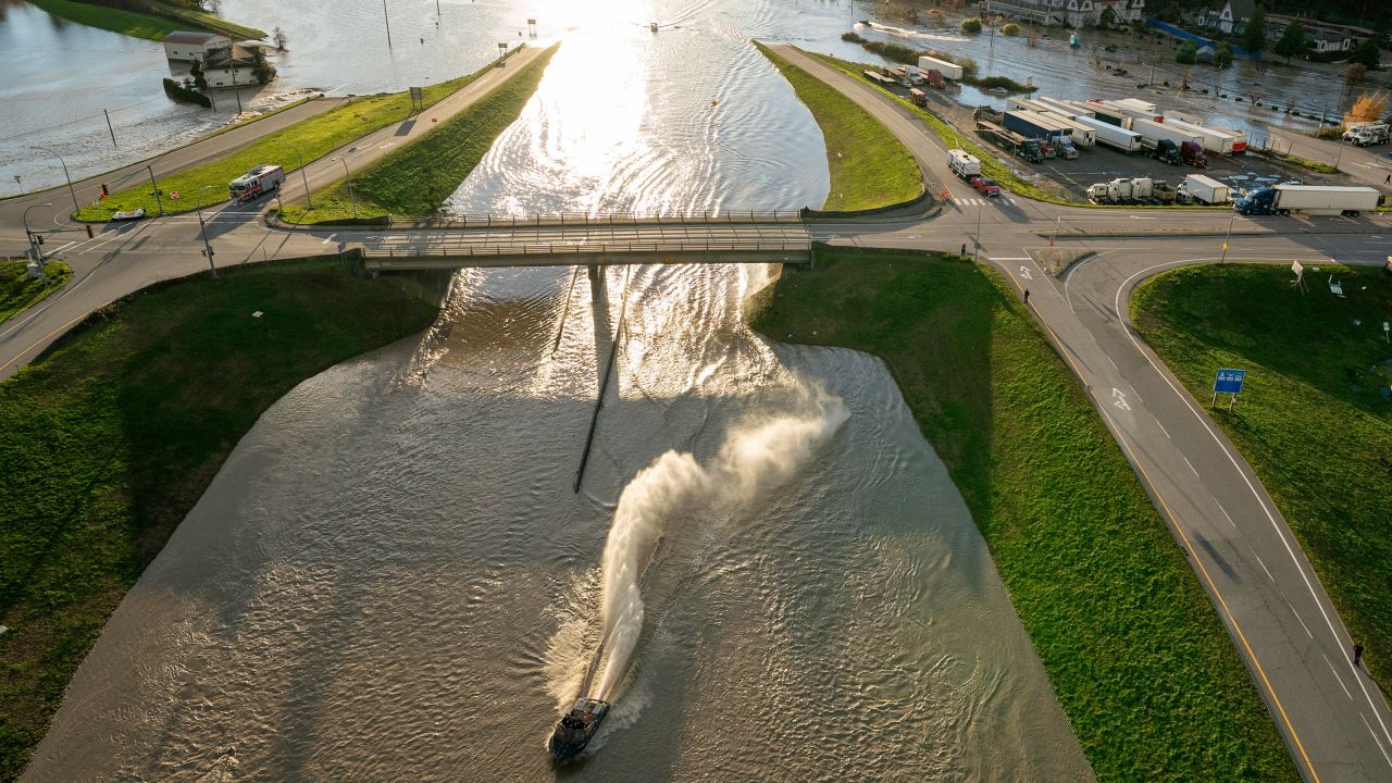 A boat goes under an overpass as it speeds along a flooded highway in Abbotsford, British Columbia.