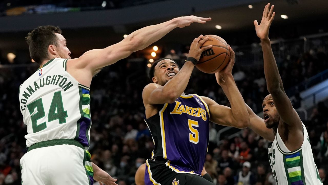 Horton-Tucker drives between Pat Connaughton and Khris Middleton during the first half.