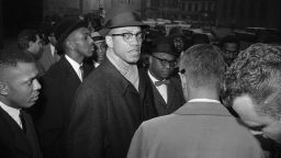 (Original Caption) 1/11/1963-New York, NY: "Malcolm X" (C), head of the New York branch of the Black Muslim religious sect, talks with newsmen during a demonstration before the trial of two members of his group. Two members of the sect were selling the Black Muslim newspaper "Muhammad Speaks," in Times Square December 25th, when police told them to move on because they were blocking a subway entrance.