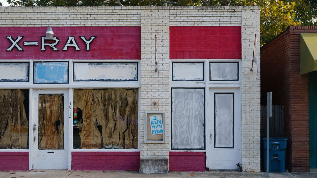 A handwritten "I Run With Maud" sign is seen on the facade of an unoccupied building in Brunswick.