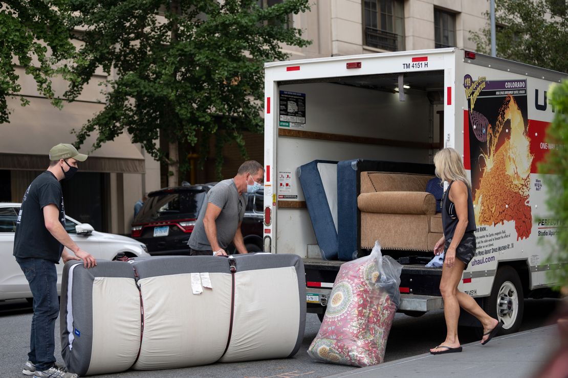 People wearing masks load furniture into a U-haul moving truck as the city continues Phase 4 of re-opening following restrictions imposed to slow the spread of coronavirus on September 12, 2020, in New York City.