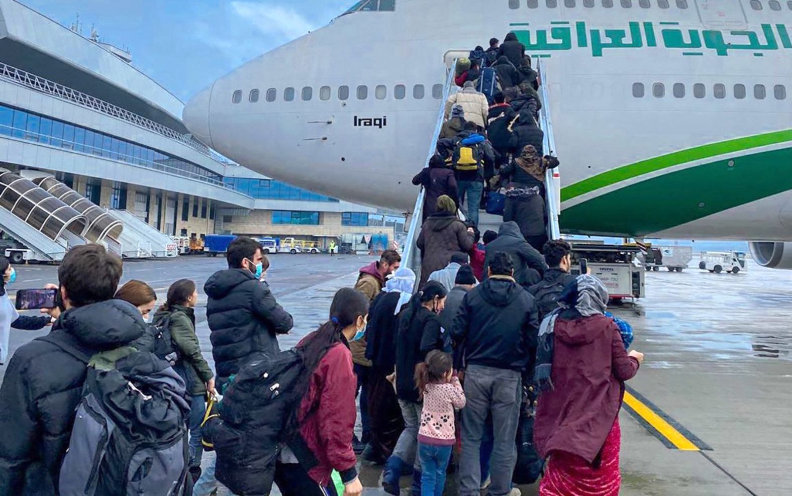 A handout picture released by Iraqi ministry of transportation on November 18, shows of Iraqi migrants boarding an Iraqi Airways plane at the Minsk airport in the Belarusian capital, to be flown to Arbil, Iraq. 