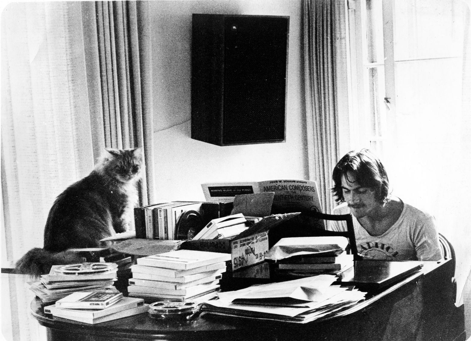 Taylor poses at a piano piled high with books and a cat named Pudding in 1972. This photo was taken by his manager and record producer Peter Asher in Los Angeles.