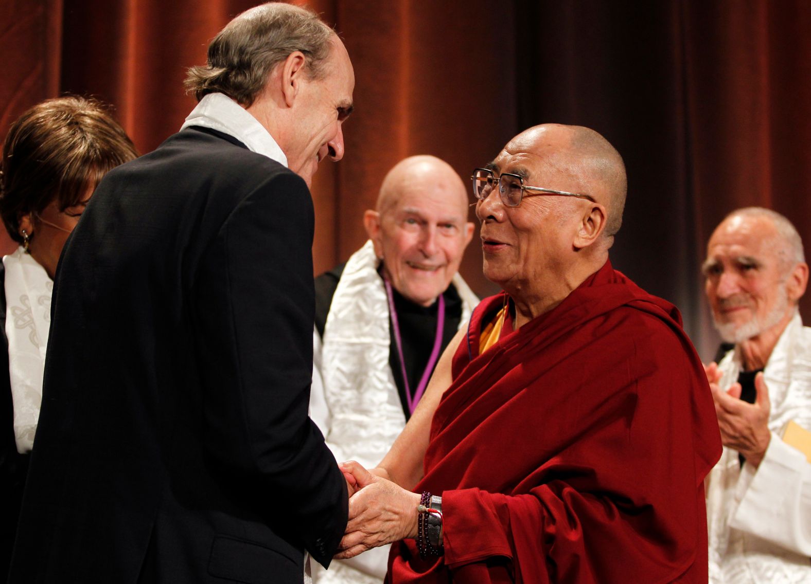 The Dalai Lama, Tibetan spiritual leader, shakes hands with Taylor following a talk titled "Beyond Religion: Ethics, Values and Wellbeing" in Boston in 2012.