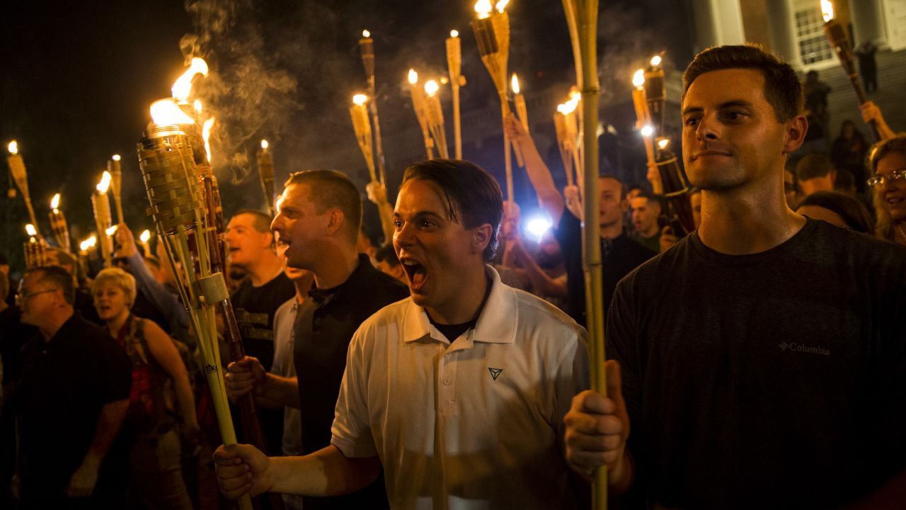 White supremacists chant at counter protesters after marching through the University of Virginia campus with torches in Charlottesville, Virginia, on August 11, 2017.