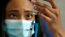 FILE - Licensed practical nurse Yokasta Castro, of Warwick, R.I., draws a Moderna COVID-19 vaccine into a syringe at a mass vaccination clinic, Wednesday, May 19, 2021, at Gillette Stadium, in Foxborough, Mass.  U.S. regulators have opened up COVID-19 booster shots to all and more adults, Friday, Nov. 19, letting them choose another dose of either the Pfizer or Moderna vaccine.  (AP Photo/Steven Senne)