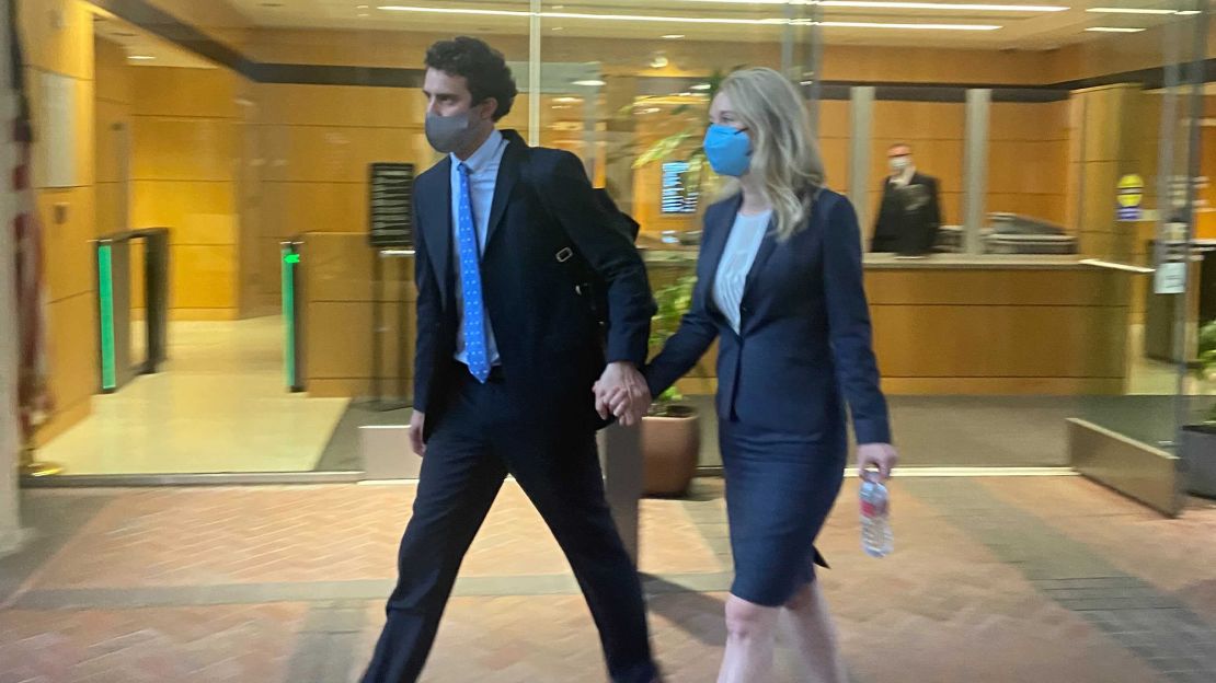Elizabeth Holmes leaves a San Jose courtroom with her partner after her first testimony.